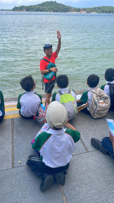 Students listening to a guide during a coastal outdoor learning programme.